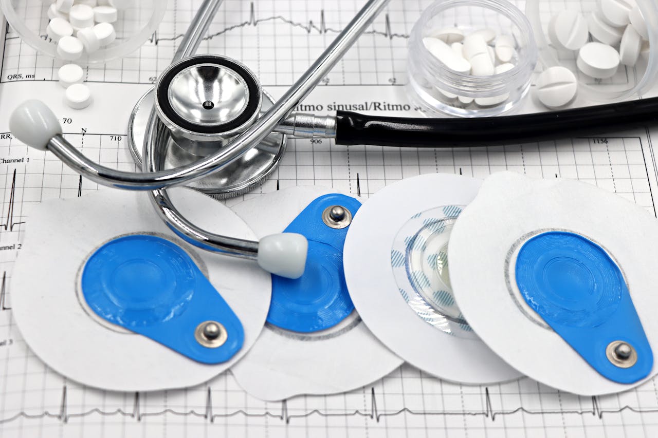 Medical instruments including stethoscope and ECG electrodes on a cardiology chart.